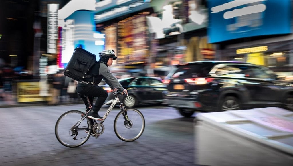 Modelo de contrato de prestação de serviços de Delivery para Restaurantes e Lanchonetes 1 | Juristas man riding bicycle near vehicles - delivery