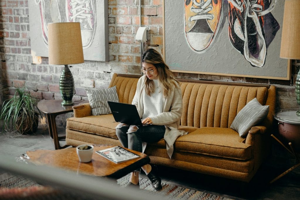 woman using laptop while sitting on chair - Registrando Marca no INPI