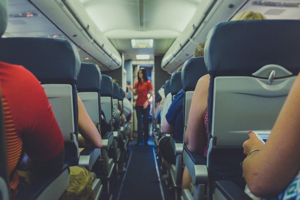 Modelo de ação indenizatória por danificar bagagem de passageiro 1 | Juristas flight attendant standing between passenger seat