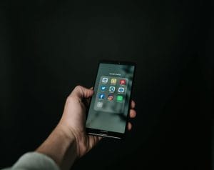 Modelo de petição de ação de reparação a título de danos morais e materiais por ser vítima de difamação via redes sociais 1 | Juristas Photo of Hand Holding a Black Smartphone