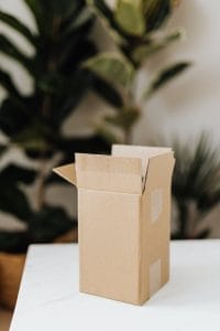 Modelo de petição de ação de reparação a título de danos morais e materiais por extravio de mercadoria pelos Correios 1 | Juristas Cardboard box on table in room with plants