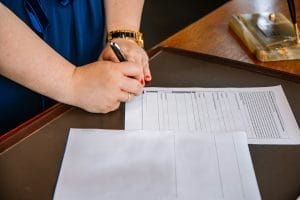 Modelo de petição de ação de reparação a título de danos morais e materiais por demora de mais de 30 dias para consertar produto em garantia 1 | Juristas person holding pen and writing on paper