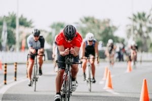 Unrecognizable cyclists riding bikes on road during race